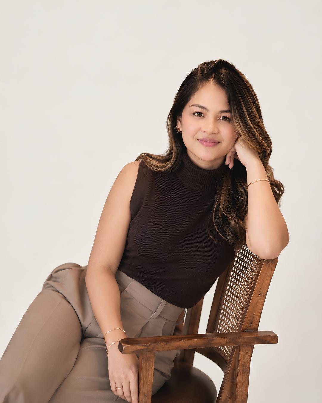 Kate Bautista, founder of Bizwork, seated on a cane chair